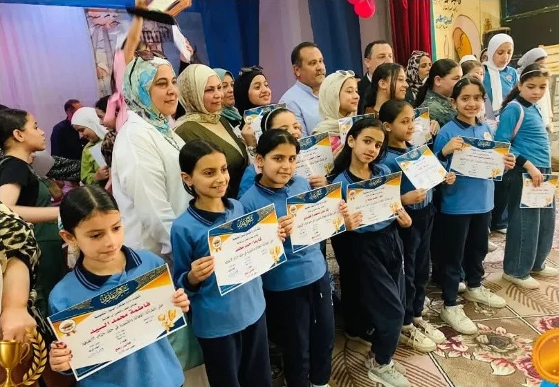 Primary students holding certificates of excellence with their teachers